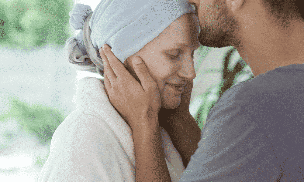 a man kissing a woman who is wearing a headscarf on the head