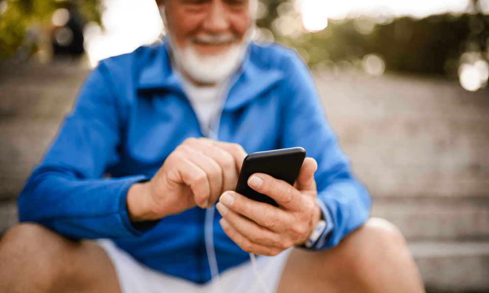 een oudere man kijkt naar een app op een smartphone
