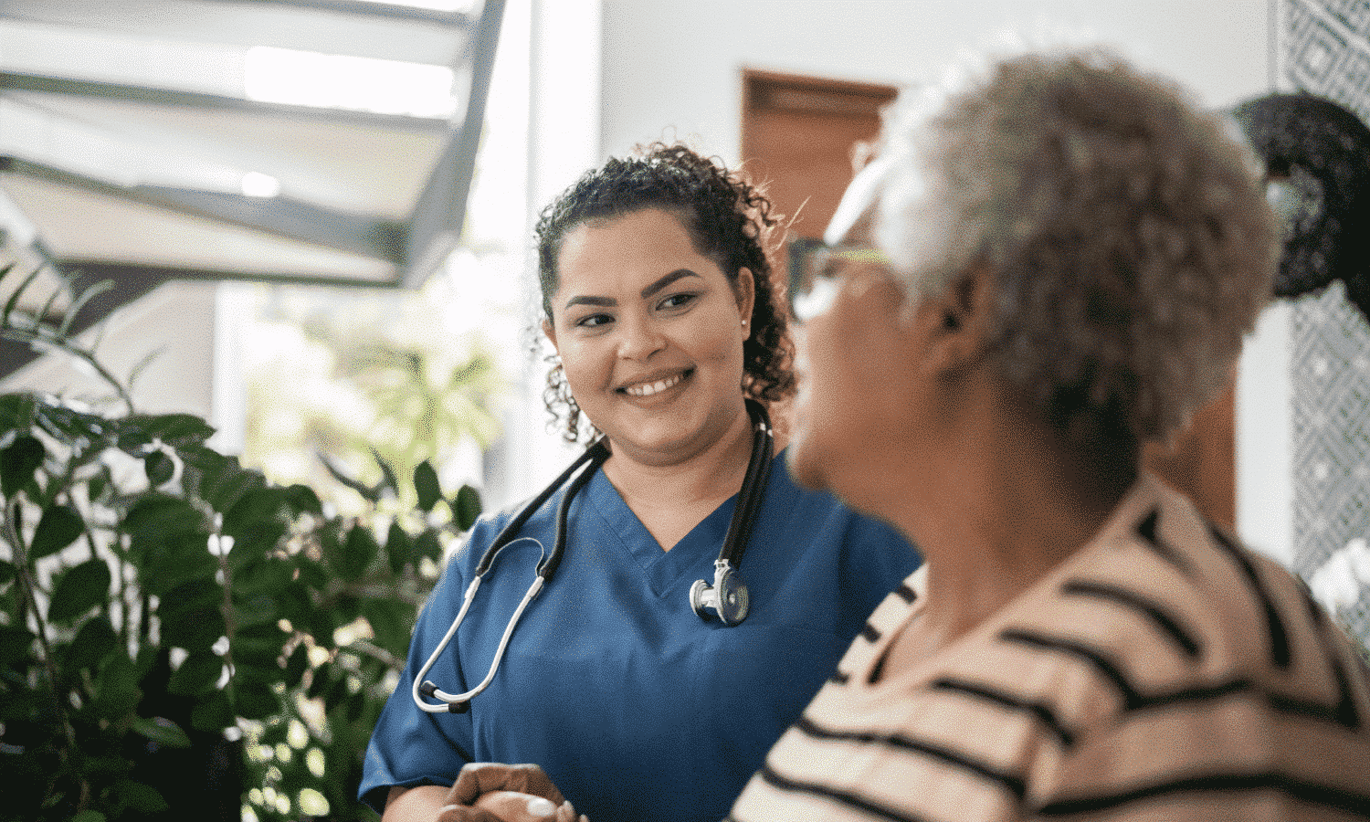 a nurse looking at an older woman and smiling